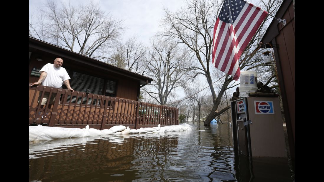 Joe Kozlowski surveys his flooded property from his porch in Fox Lake on April 22. Downpours have created flooding concerns for rivers in Illinois, Missouri, Iowa, Indiana and Michigan, the National Weather Service said.