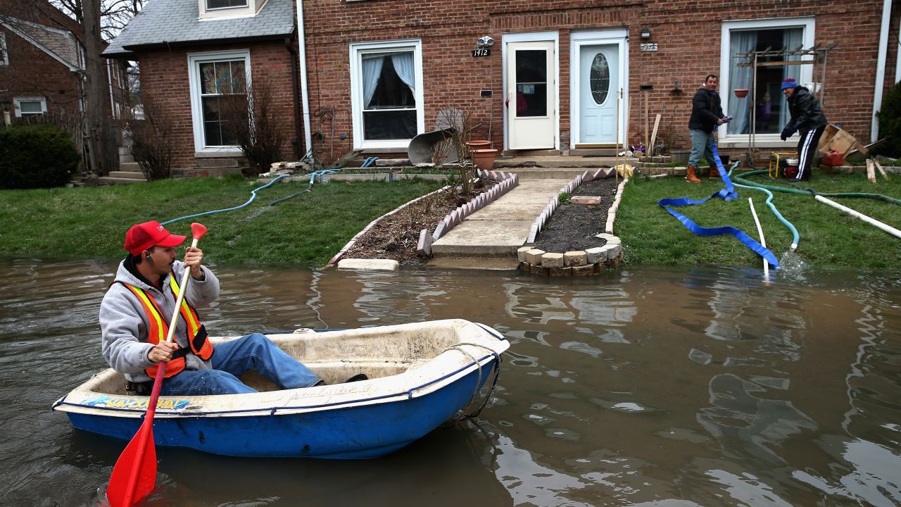 Octavio Castillo paddles down a flooded street on Friday, April 19, in Des Plaines, Illinois, a suburb of Chicago.
