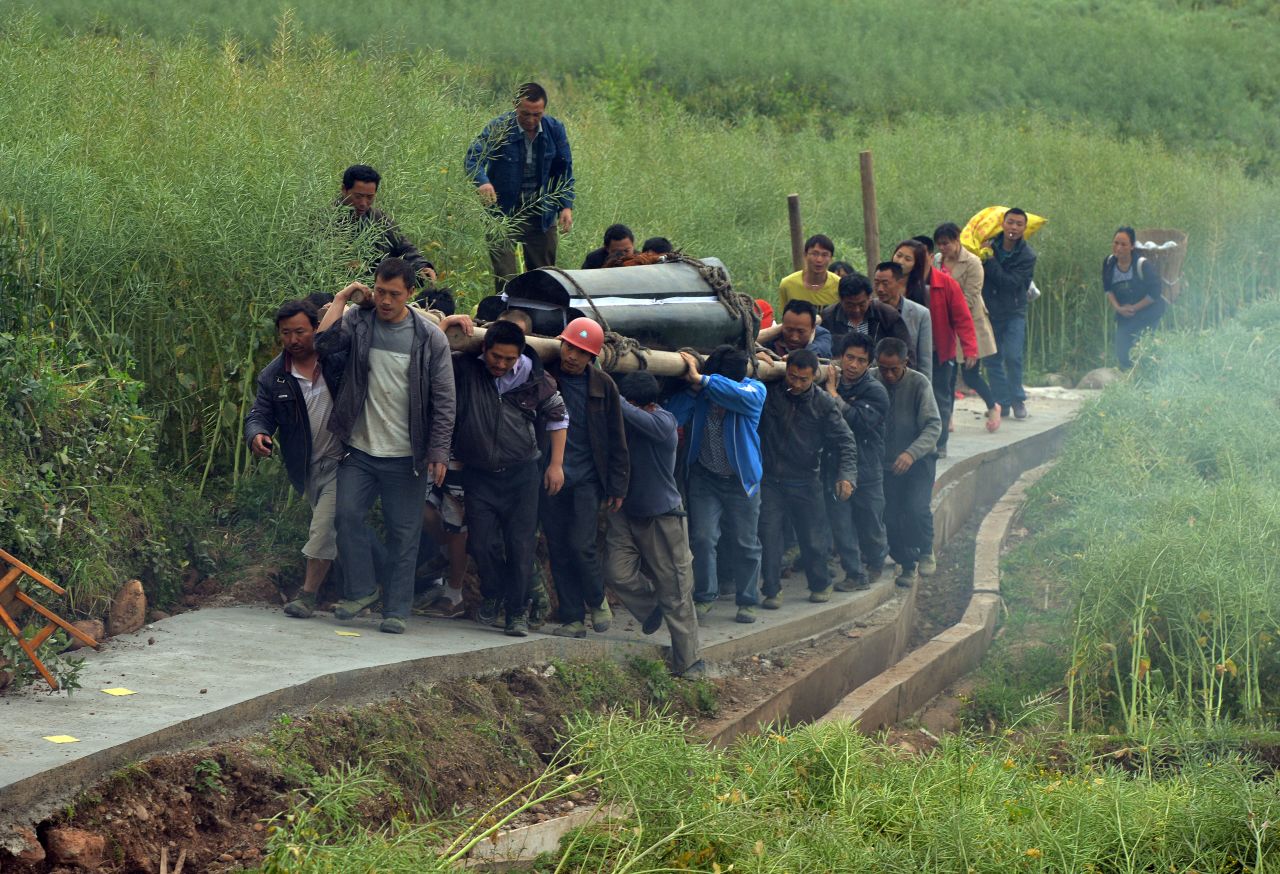 Villagers carry the coffin of a man killed in the earthquake in Lushan, Sichuan Province, on Monday, April 22.