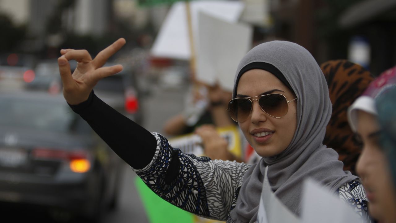 A woman makes a peace sign gesture at a protest in Los Angeles, California, against religious hatred.

