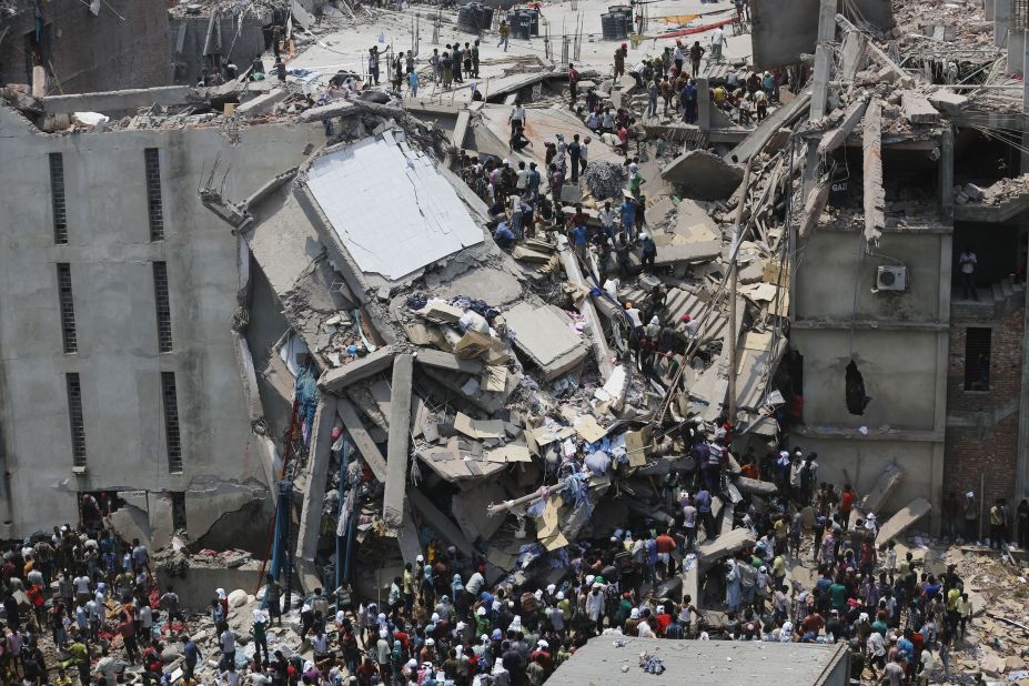 People rescue garment workers on Wednesday, April 24, after the building caved in, leaving a chaotic mass of broken concrete and twisted metal.<br />