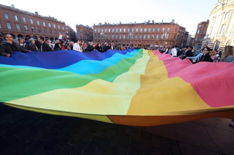 People unfurl a rainbow banner in Toulouse on April 23 after the lower house vote.