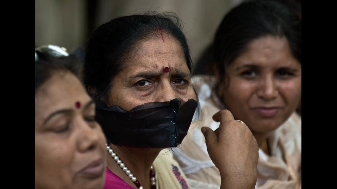 A woman covers her mouth with a black cloth during Tuesday's protest in New Delhi.