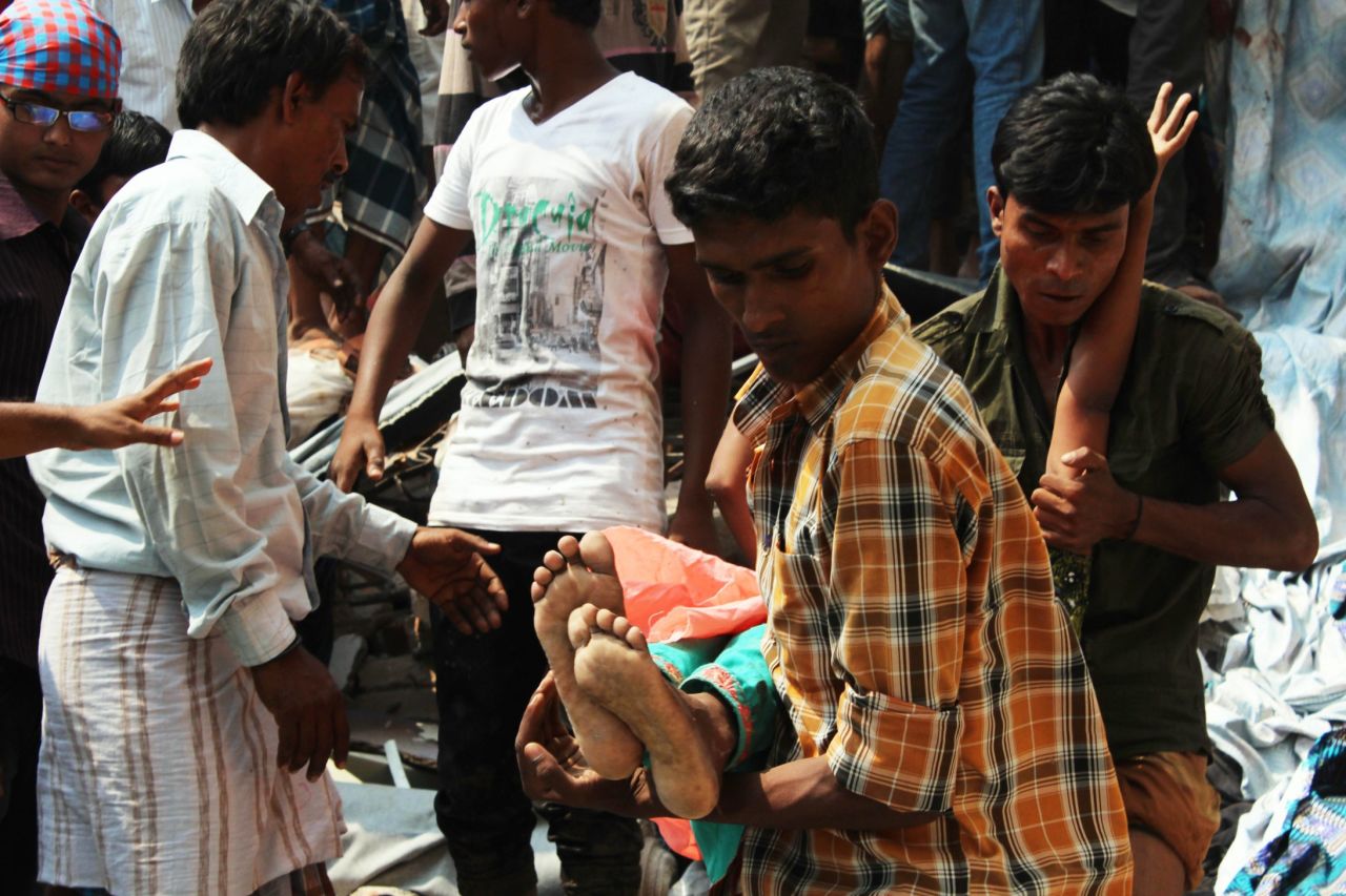 Rescuers bring out an injured garment worker from the building's sixth floor.
