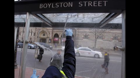 A man washes a bus stop window on Boylston Street on April 24.