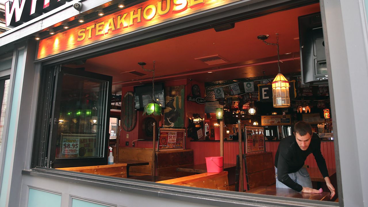 Alec Mikels cleans tables at Whiskey's Smokehouse on Boylston Street on Tuesday, April 23 in Boston.