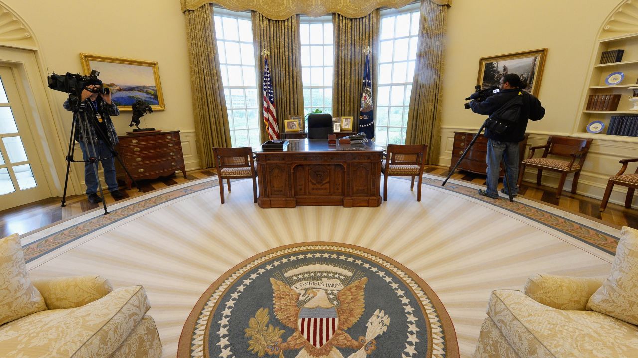 Members of the media shoot video inside a recreated White House Oval Office during a tour of the George W. Bush Presidential Center.