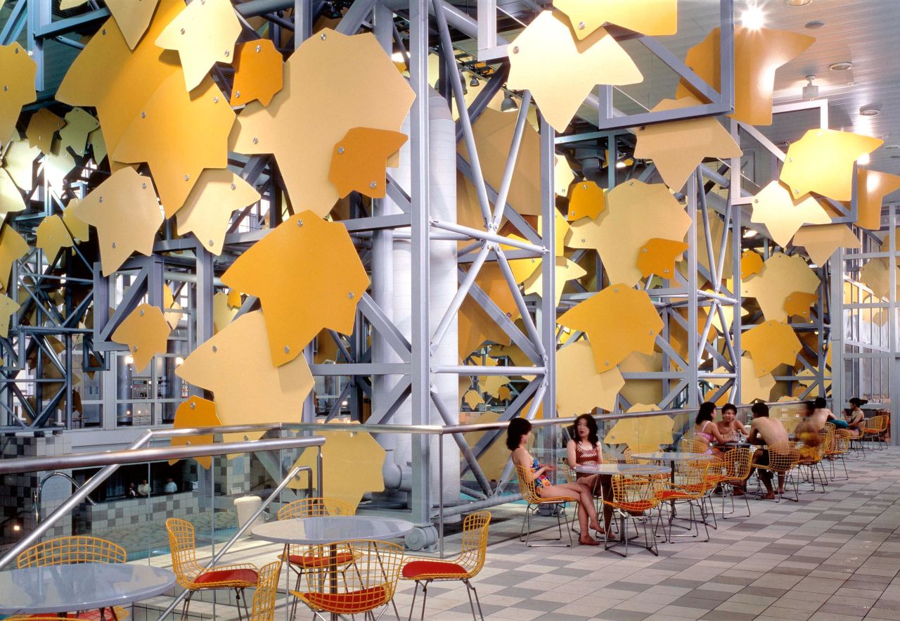 The spa facade is ornamented with giant green and yellow aluminum tree leaves.