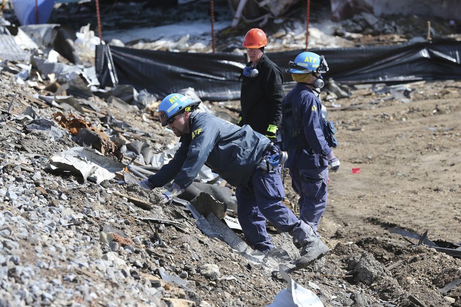 Agents from the Bureau of Alcohol, Tobacco, Firearms and Explosives search the bank of rail tracks for evidence at the site of the explosion.