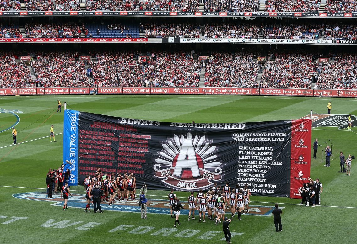 The Essendon Bombers and Collingwood Magpies players walk through the ANZAC Day banner during the round five of their match at the Melbourne Cricket Ground on Thursday.