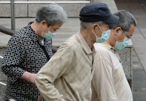Three people wearing masks walk outside the National Taiwan University Hospital in Taipei on Thursday, April 25. China has reported 83 cases of H7N9 avian influenza. 
