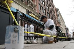 Workers at a Boylston Street restaurant paint over the damage caused by the Boston marathon bombings.