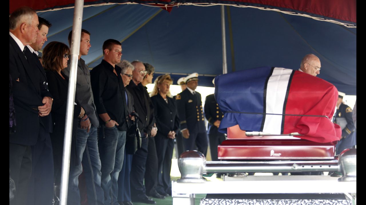 Family and friends stand in front of Harris' casket at the cemetery on April 24.