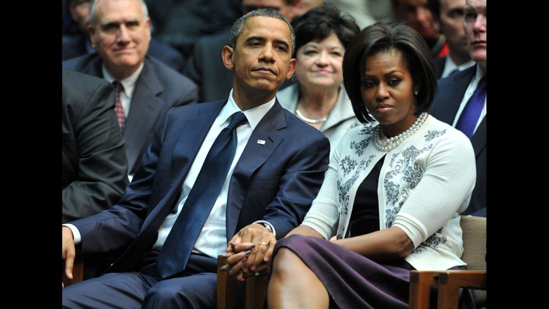 The President and first lady hold hands during a memorial service for the victims of a Tucson, Arizona, shooting. On January 8, 2011, Jared Lee Loughner shot six people and wounded 13 more, including then-Rep. Gabrielle Giffords.