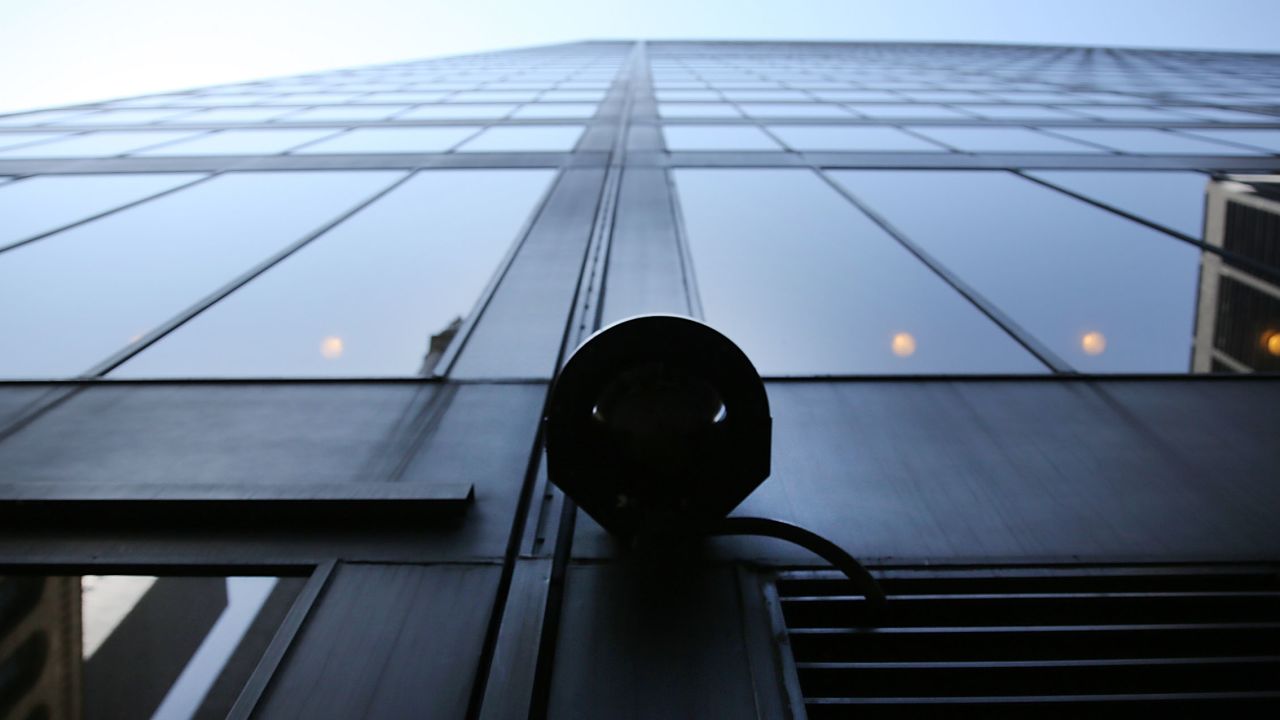 A surveillance camera attached to a building in the Financial District of New York City.