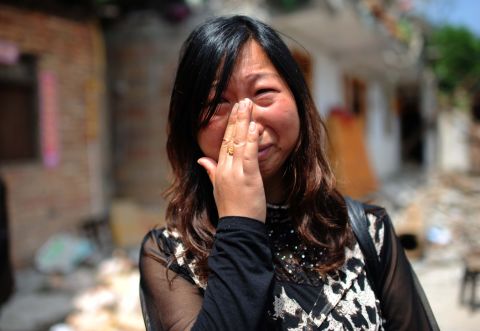 A woman who lost her son in the earthquake cries in front of her damaged home in Ya'an on April 24.