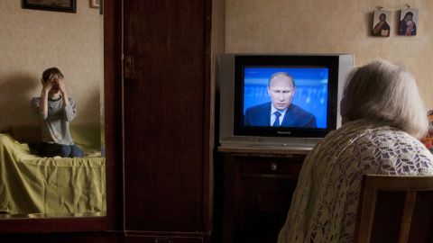 An elderly woman watches President Vladimir Putin's televised question and answer session in Moscow, on April 25, 2013.