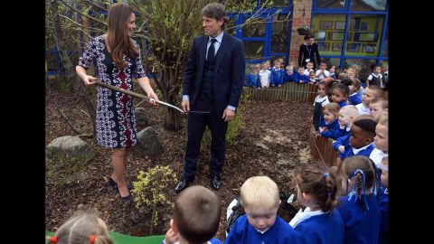 During a visit on April 23 to the Willows Primary School in Manchester, the Duchess plants a willow tree with comedian John Bishop to launch a new school counseling program.