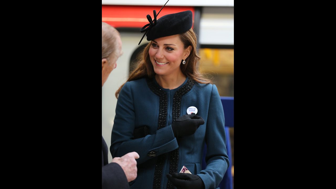 To mark the 150th anniversary of the London Underground on March 20, the Duchess of Cambridge visits the Baker Street Underground Station, wearing a pin that reads, "Baby on Board!"