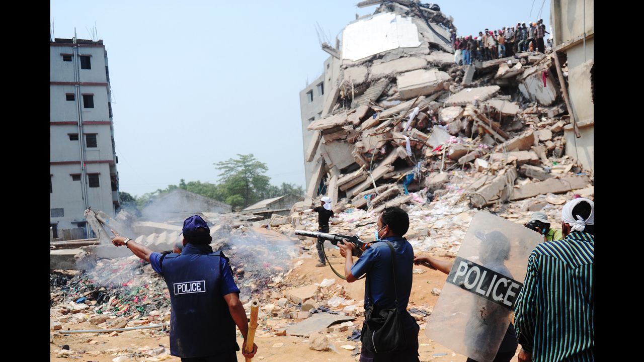 Bangladeshi police fire tear gas at protesters amid the rubble of the building.