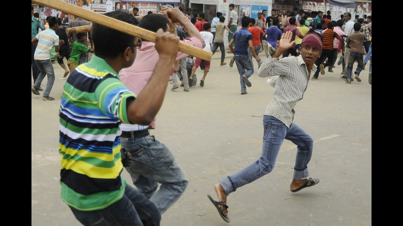 Plainclothes Bangladeshi police brandish sticks as they attempt to break up protests.