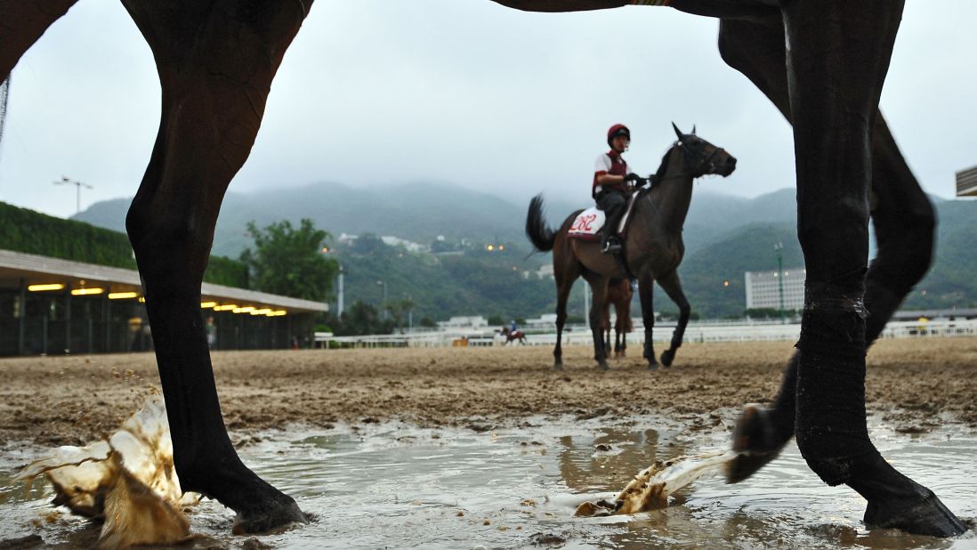 Horses and jockeys return to stables in damp weather at the Sha Tin Racecourse in Hong Kong on Friday, April 26. Preparations are under way for the upcoming Audemars Piguet Queen Elizabeth II Cup. 