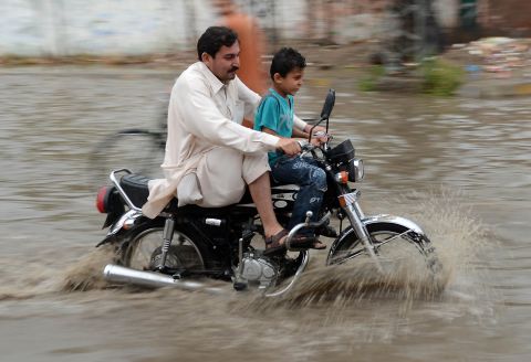 A Pakistani motorcyclist crosses a flooded street after heavy rain in Peshawar on April 26. Pakistan has suffered devastating monsoon floods for the last three years, including the worst in its history in 2010, when catastrophic inundations killed almost 1,800 people and affected 21 million. 