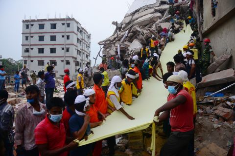 Rescue workers use textile as a slide to move bodies out of the rubble on April 26.