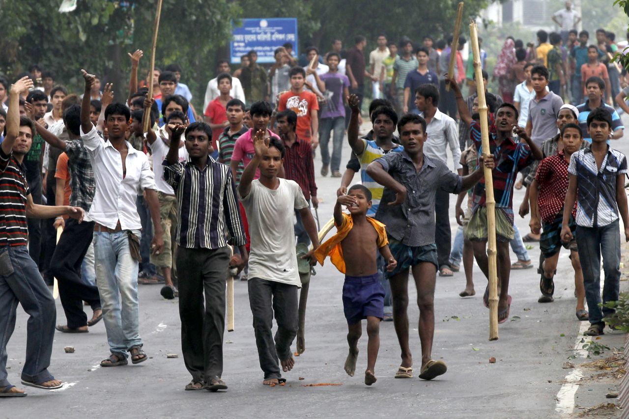 Bangladeshi garment workers protest in Savar on Saturday, April 27. Four people were arrested and four others are being questioned by police. The building owner has gone into hiding.