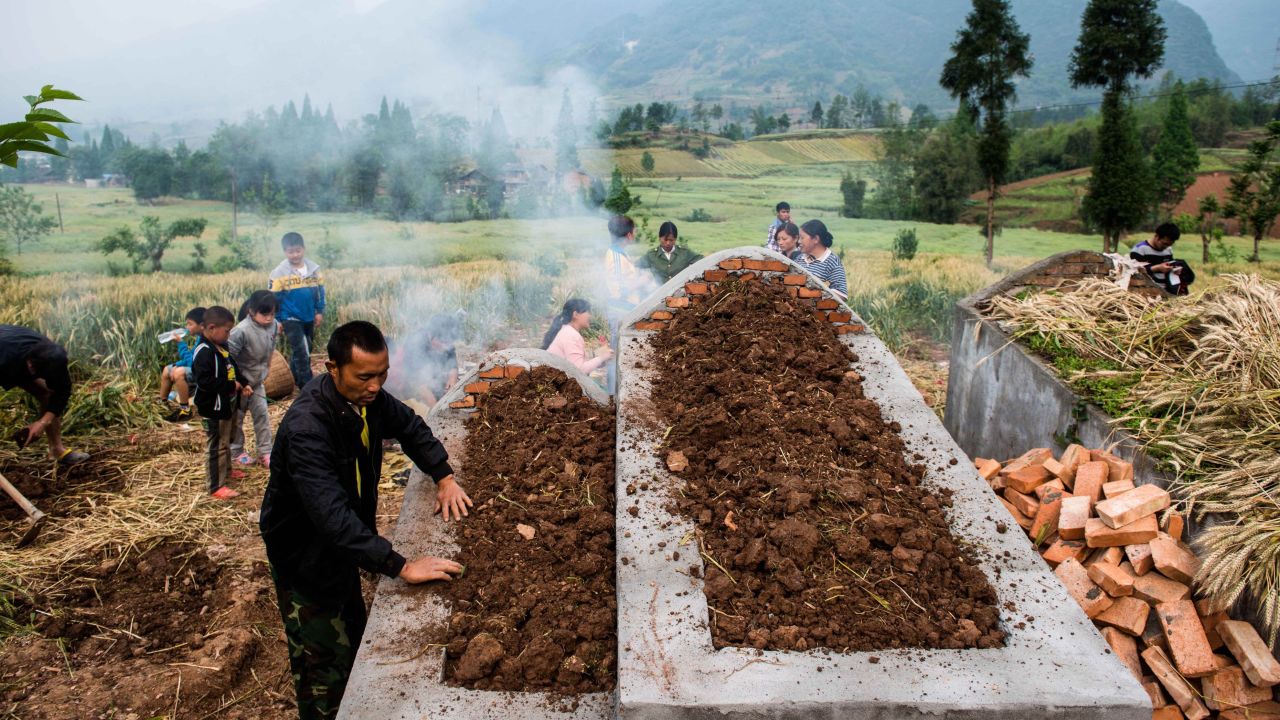 People pay their respects at a newly built grave in Ya'an, China, on Saturday, April 27, one week after a 6.6-magnitude earthquake. More than 190 people died and thousands were injured after the quake struck China's southwest Sichuan province on April 20, state media reported.