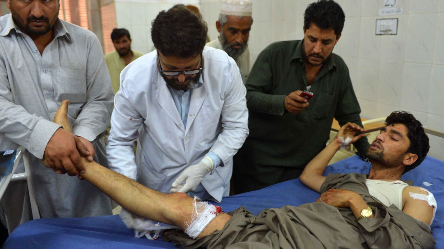 Pakistani paramedics treat an injured man following a bomb blast in Peshawar on April 29, 2013.