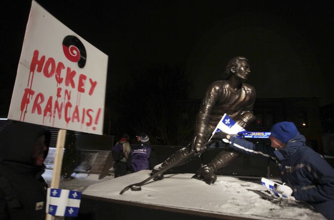 A protester places a Quebec flag on a statue of former NHL hockey player Guy Lafleur in Montreal. While Quebecers don't participate in hockey en masse the way they used to, it's still the most popular sport there.