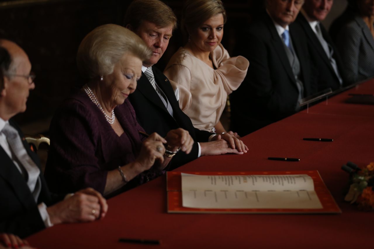 Beatriz firma el Acta de Abdicación junto a su hijo Guillermo Alejandro y Máxima durante una ceremonia en Amsterdam este 30 de abril de 2013.