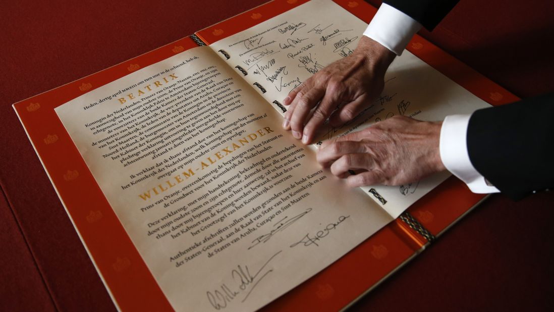 A man displays the Act of Abdication signed by Princess Beatrix, her son King Willem-Alexander and his wife Queen Maxima during the abdication ceremony.