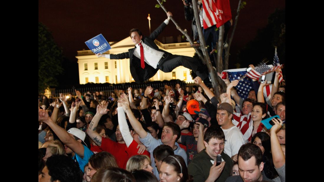 Revelers gather at the fence on the north side of the White House.