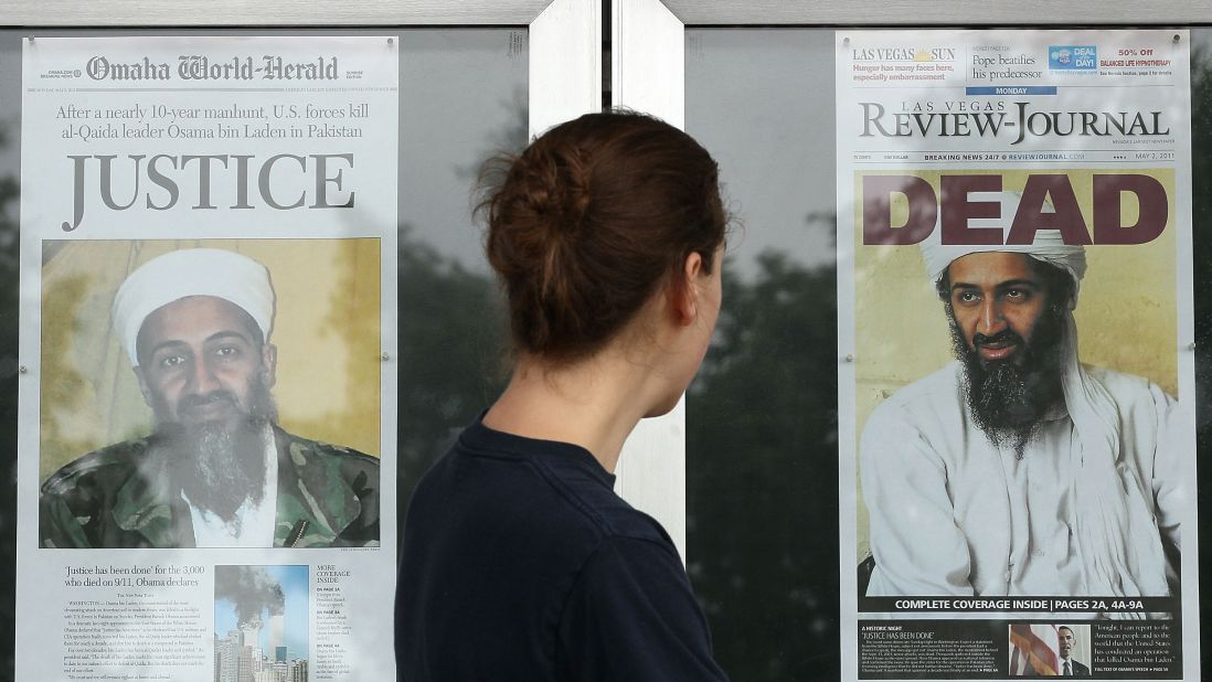 A passer-by looks at newspaper headlines in front of the Newseum in Washington.