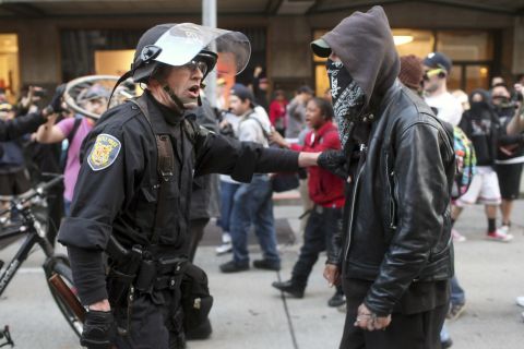 A police officer and demonstrator clash during May Day demonstrations in Seattle on Wednesday, May 1. A peaceful protest turned violent, and police say they sprayed demonstrators with pepper spray after they threw everything from metal pipes to fireworks at officers. Hundreds of thousands of people across the globe take to the streets on May 1 to demand better working conditions during what is known as International Workers' Day.