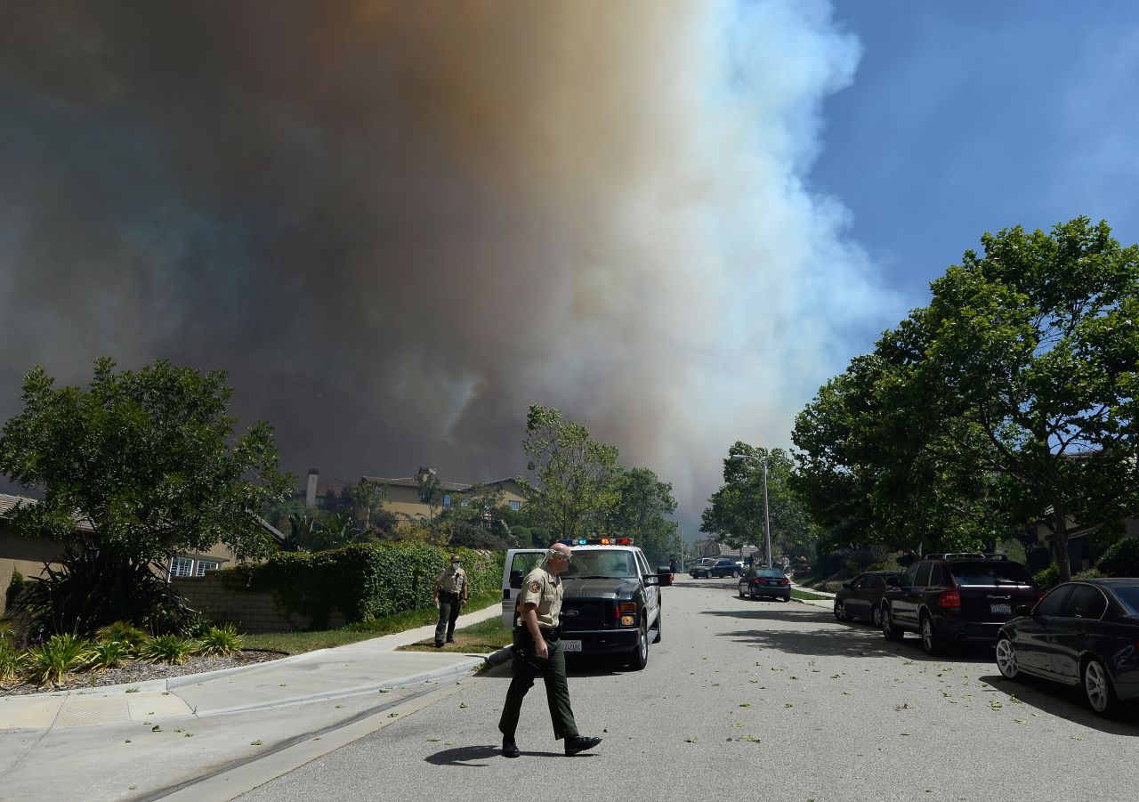 Ventura County fire officials go door-to-door asking residents if they need assistance as a wildfire approaches homes on Thursday. The wildfire has burned 6,500 acres.