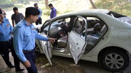 Pakistani police officials examine the bullet-riddled car of slain government prosecutor Chaudhry Zulfiqar after an attack by gunmen in Islamabad on May 3, 2013.
