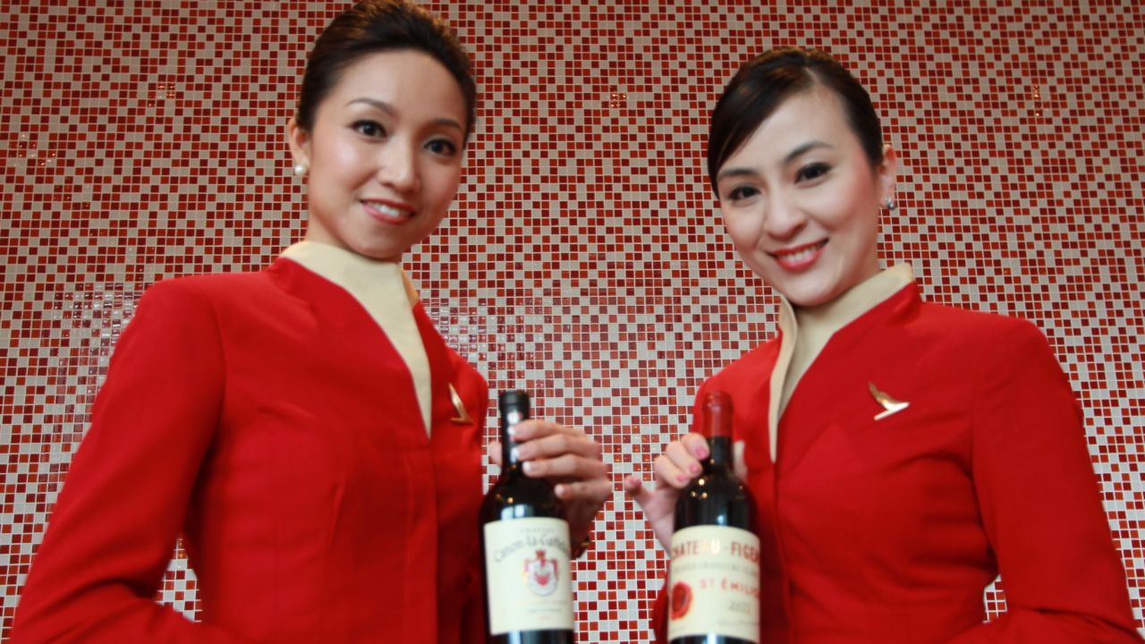 Cabin cru: Cathay Pacific stewardesses proffer the airline's latest reds