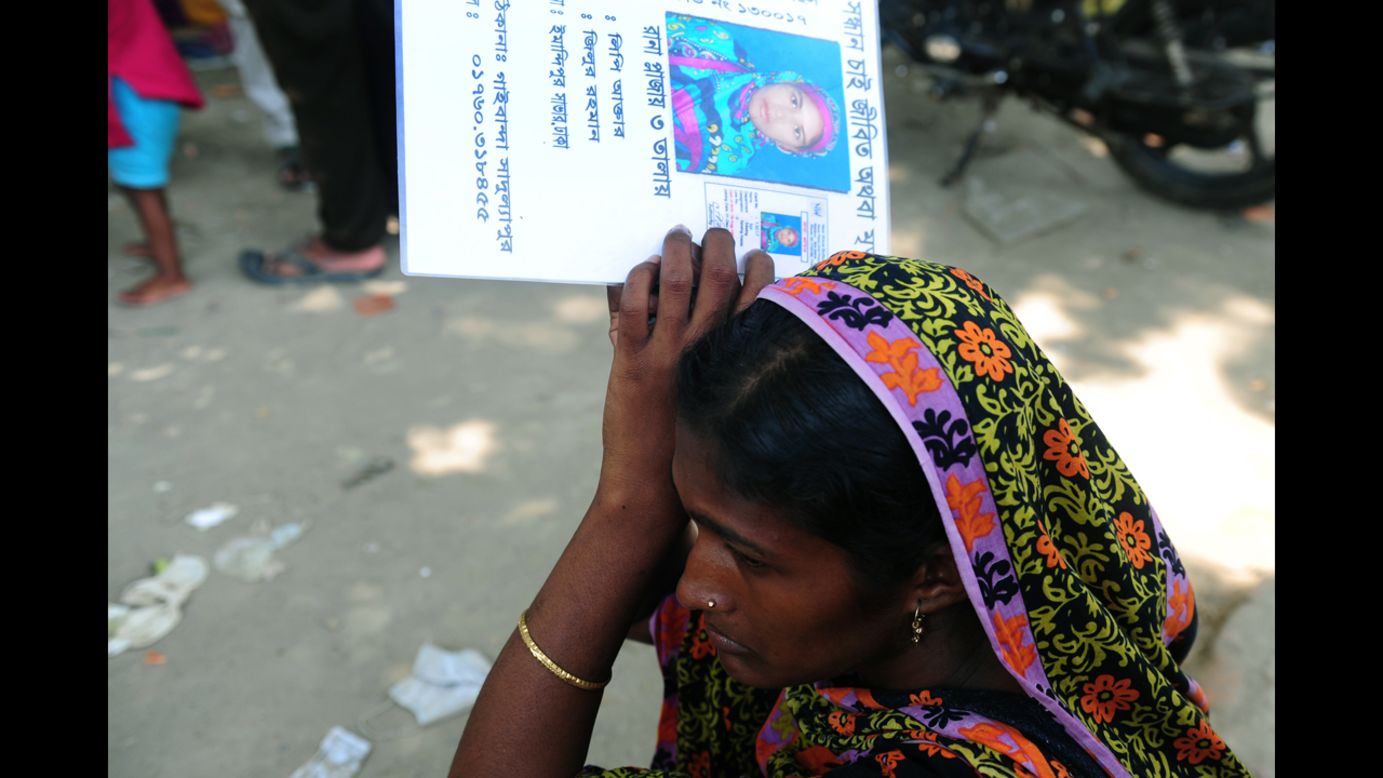 A woman holds up a picture of a missing person believed to be trapped in the rubble on May 3.