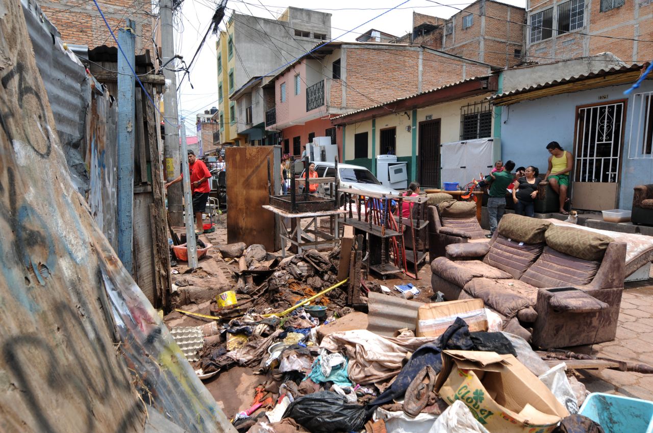People in the Morazan neighborhood of Tegucigalpa, Honduras, sort through the remains of their possessions after heavy rains left two people missing and destroyed streets and homes.
