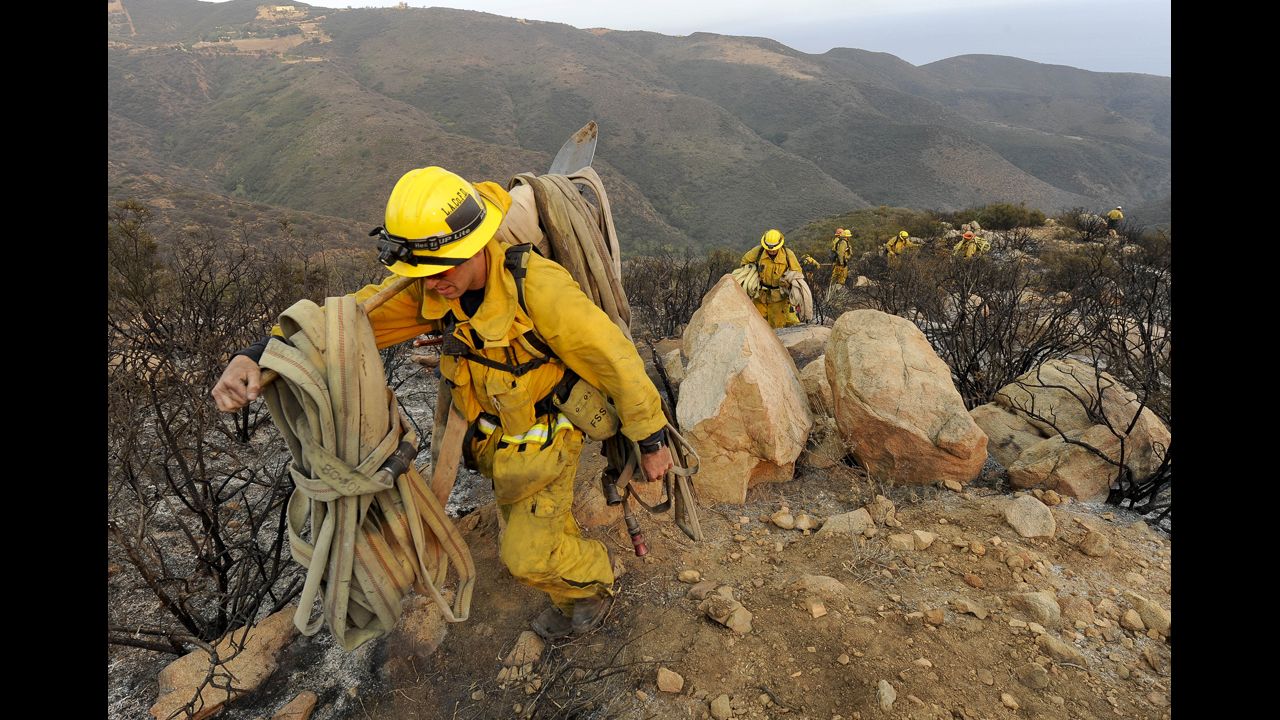 Firefighters make their way out of a canyon near Malibu, California, on May 3.