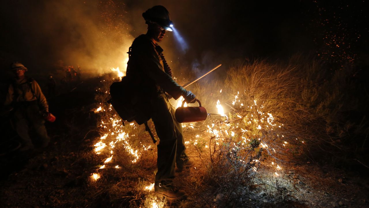 Firefighter Justin Romero of the New Mexico-based Silver City Hotshots uses a drip torch to build a backfire up the mountain off Potrero Road to control the Springs Fire near Newbury Park, California, on Friday, May 3. Winds have made fighting the Springs Fire blaze more difficult, and authorities have ordered mandatory evacuations of homes and the campus of California State University, Channel Islands.