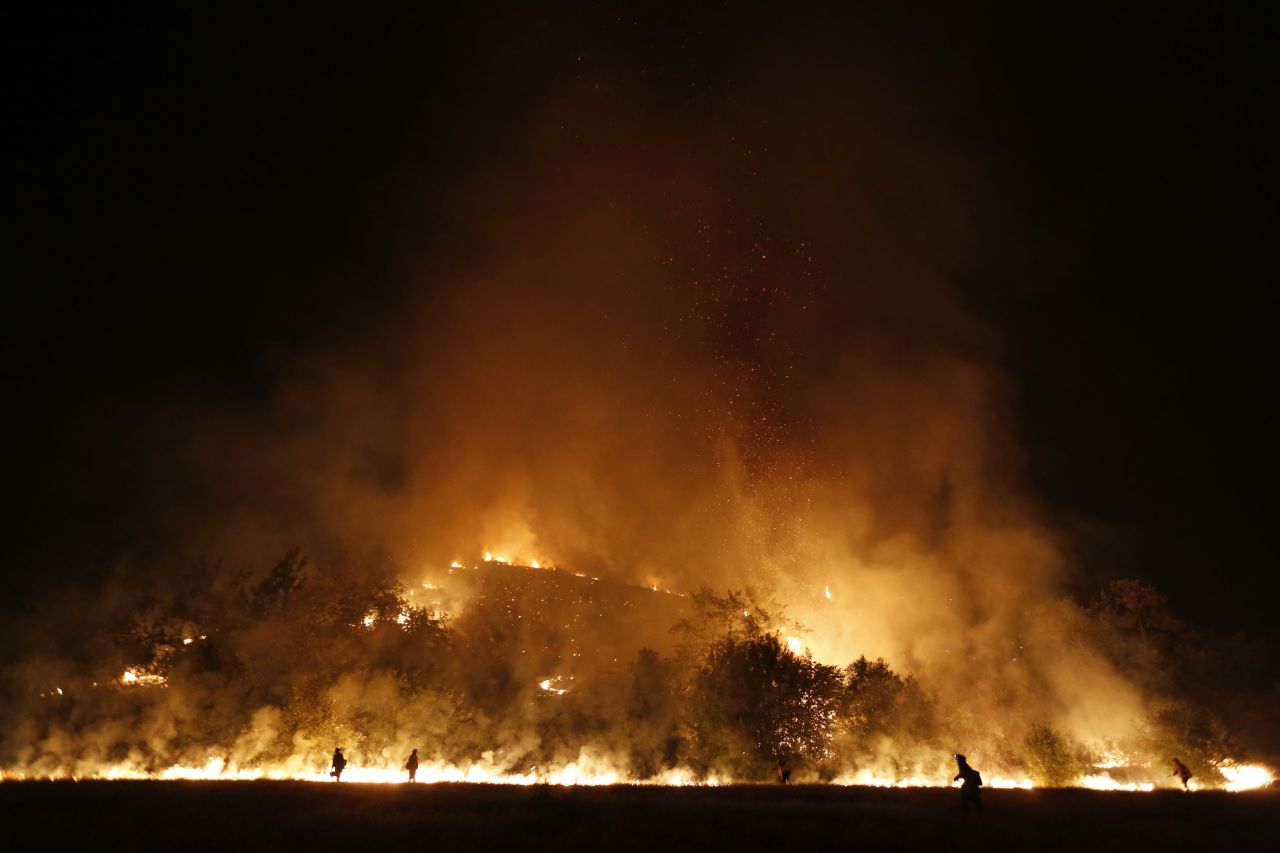 Firefighters start a backfire into the Santa Monica Mountains to help control the Springs Fire in southeast Ventura County, California, on Saturday, May 4. The fire damaged 15 homes and five commercial properties and destroyed 25 outbuildings  in the Los Angeles area as of Saturday, fire authorities said.