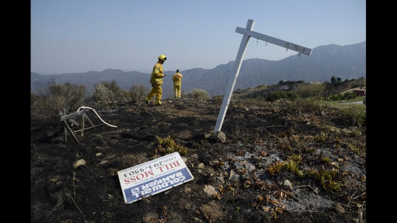 Firefighters monitor the fire-scorched hills near Point Mugu State Park on May 4.