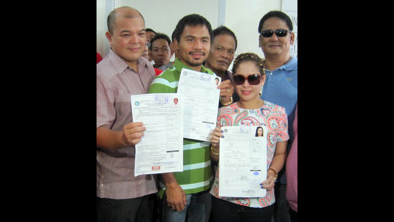Pacquiao, center, and his wife Jinkee, right, display their certificates of candidacy at the election office in Alabel, Sarangani province, in the southern island of Mindanao, on October 2, 2012. Pacquiao registered to run for reelection as a congressman for the southern province of Sarangani, with Jinkee filing to stand for vice-governor. 
