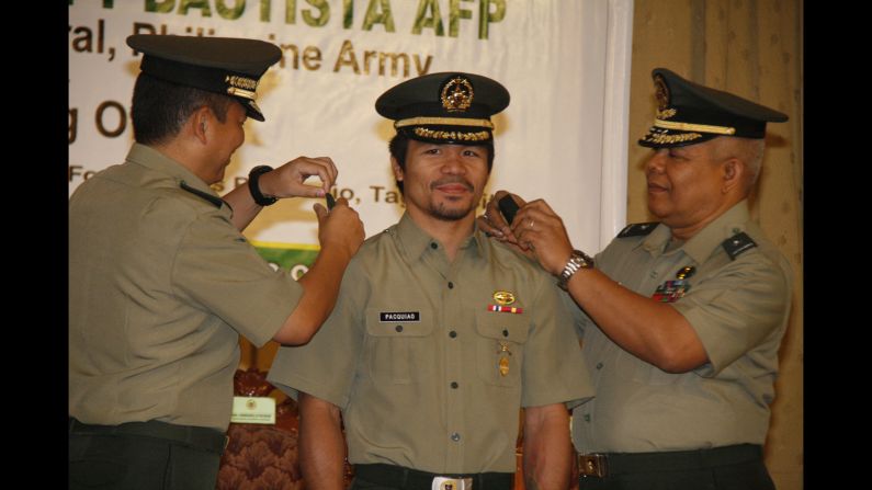 Pacquiao is conferred the rank of lieutenant colonel by Maj. Gen. Emmanuel Bautista, left, and Brig. Gen. Alex Albano, right, in Manila, on December 5, 2011.