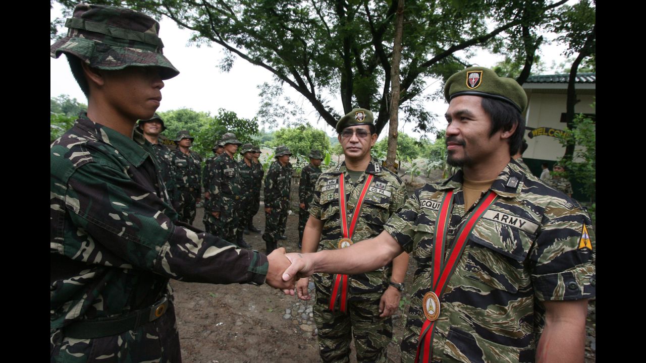 Pacquiao shakes hands with a Special Forces Operation Course student during the 49th Special Forces Regiment anniversary at Fort Magsaysay in Nueva Ecija, north of Manila, on June 27, 2011. During the event, Pacquiao received the Honorary Special Forces Warrior Badge, and wore the exclusive Special Forces uniform popularly known as the "Tiger suit."