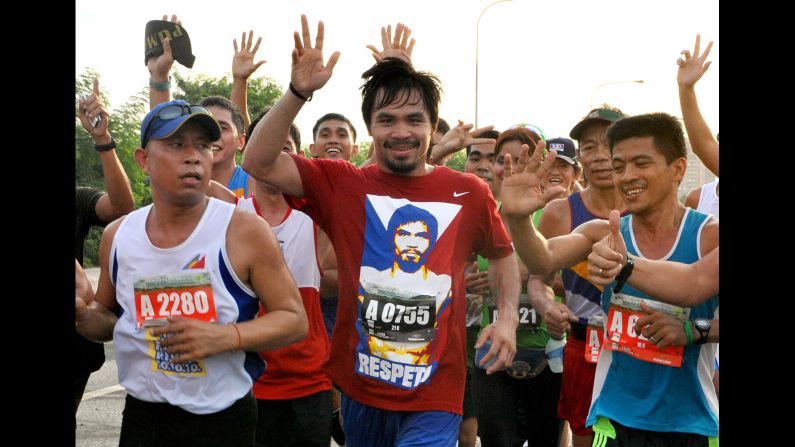 Pacquiao waves as he joins hundreds of other runners in Manila on October 10, 2010, to raise funds and environmental awareness to help revive the Pasig River, a heavily polluted major waterway that cuts through the city of 12 million.